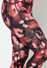 Zwart-roze patroonlegging met een gladde textuur, voorzien van een zijnaaddetail en een abstract bloemenontwerp.