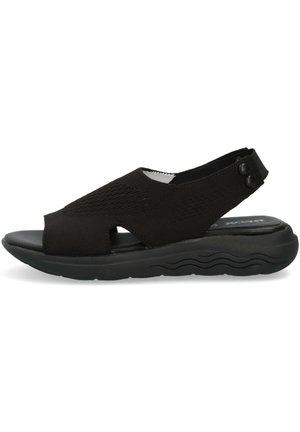 Sandalo nero con tomaia in maglia, design con punta aperta, cinturino regolabile e suola imbottita con texture a motivo ondulato.