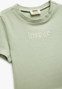 Lys gr�øn bomulds t-shirt med rund halsudskæring, korte ærmer og broderet "Inspire" detail på fronten.