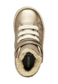 Sneaker metallico dorato con lacci elastici bianchi e cinturino in Velcro, dotato di una morbida fodera soffice e una suola testurizzata per una migliore aderenza.