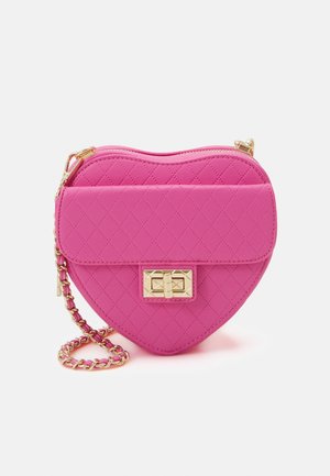 Różowa skórzana torba na ramię w kształcie serca, pikowana, z paskiem na złotym łańcuszku oraz prostokątną złotą klamrą na przednim klapie.
