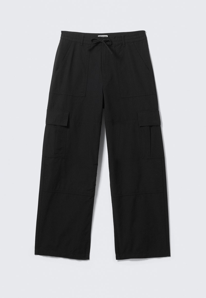 Pantalon cargo large noir avec poches avant, poches à rabat sur les cuisses, passants de ceinture et taille à cordon, posé à plat sur un fond blanc.