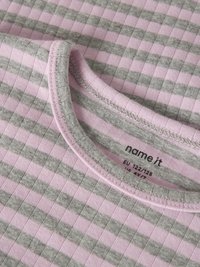 Nahaufnahme eines rosa- und grau gestreiften Stoffs mit geripptem Muster und einer Naht am runden Halsausschnitt.