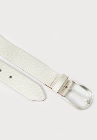 Vit läderbälte med texturerad yta, silvermetallspänne och fem justeringshål. Rena linjer och elegant design.