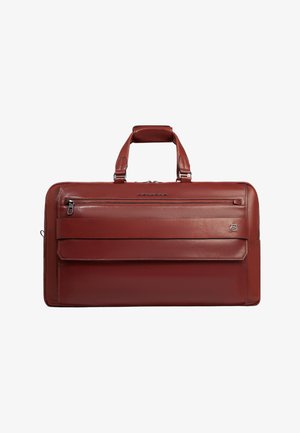 Mallette en cuir rouge foncé avec double poignées, poche zippée avant et une sangle horizontale traversant le panneau avant sur un fond blanc.