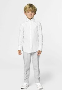 Witte blouse met lange mouwen en knopen aan de voorkant, gecombineerd met lichtgrijze tappered broeken en witte sneakers, met een rechte kraag en een gladde textuur.