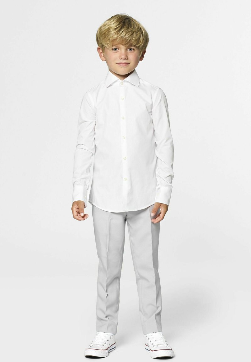 Witte blouse met lange mouwen en knopen aan de voorkant, gecombineerd met lichtgrijze tappered broeken en witte sneakers, met een rechte kraag en een gladde textuur.