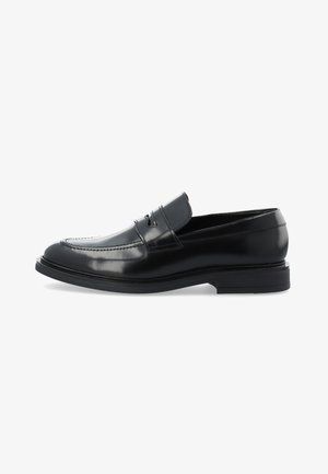Mocassins en cuir noir avec une finition lisse et brillante, présentant un bandeau légèrement surélevé à l'avant et une semelle noire basse et robuste.