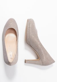 Błyszczące beżowe szpilki z okrągłym noskiem, gładką skórzaną podszewką i zwężającym się obcasem, z teksturowanym wierzchem i minimalnym zdobieniem.