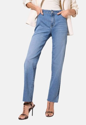Jeans in denim blu chiaro con vita alta, design a gamba dritta, cinque tasche e dettagli di cucitura. Abbinati a tacchi neri con cinturini.