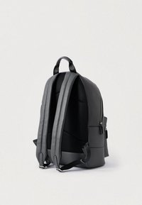 Μαύρος δερμάτινος σακίδιο με επενδυμένες πλέγματες ιμάντες, φερμουάρ κλεισίματος και εξωτερική τσέπη. Κομψός σχεδιασμός με δομημένο σχήμα.