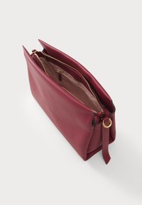 Bordeaux lædertaske med en glat tekstur, dobbelt lynlås og guldfarvet hardware. Har en indvendig lomme og en elegant, struktureret form.