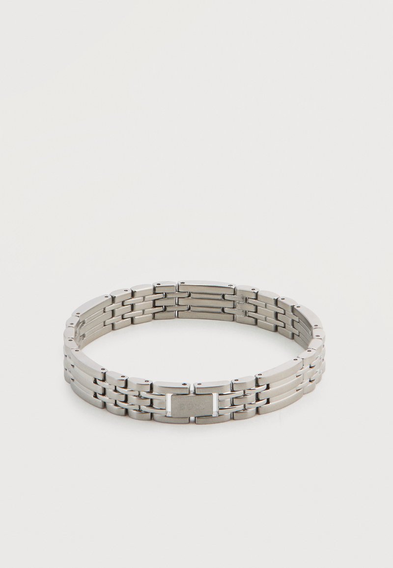 Ασημένιο μεταλλικό βραχιόλι με επίπεδη πόρπη, που διαθέτει ορθογώνιους και στρογγυλεμένους κρίκους σε επαναλαμβανόμενο μοτίβο.