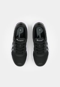 Chaussures de sport noires avec un dessus texturé, des accents blancs et un col rembourré. L'intérieur présente une semelle intérieure à motifs et un logo.