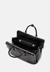 Sac en cuir noir avec fermeture éclair, double poignées et un intérieur spacieux comprenant une poche plaquée. Texture lisse avec des accents en métal argenté.