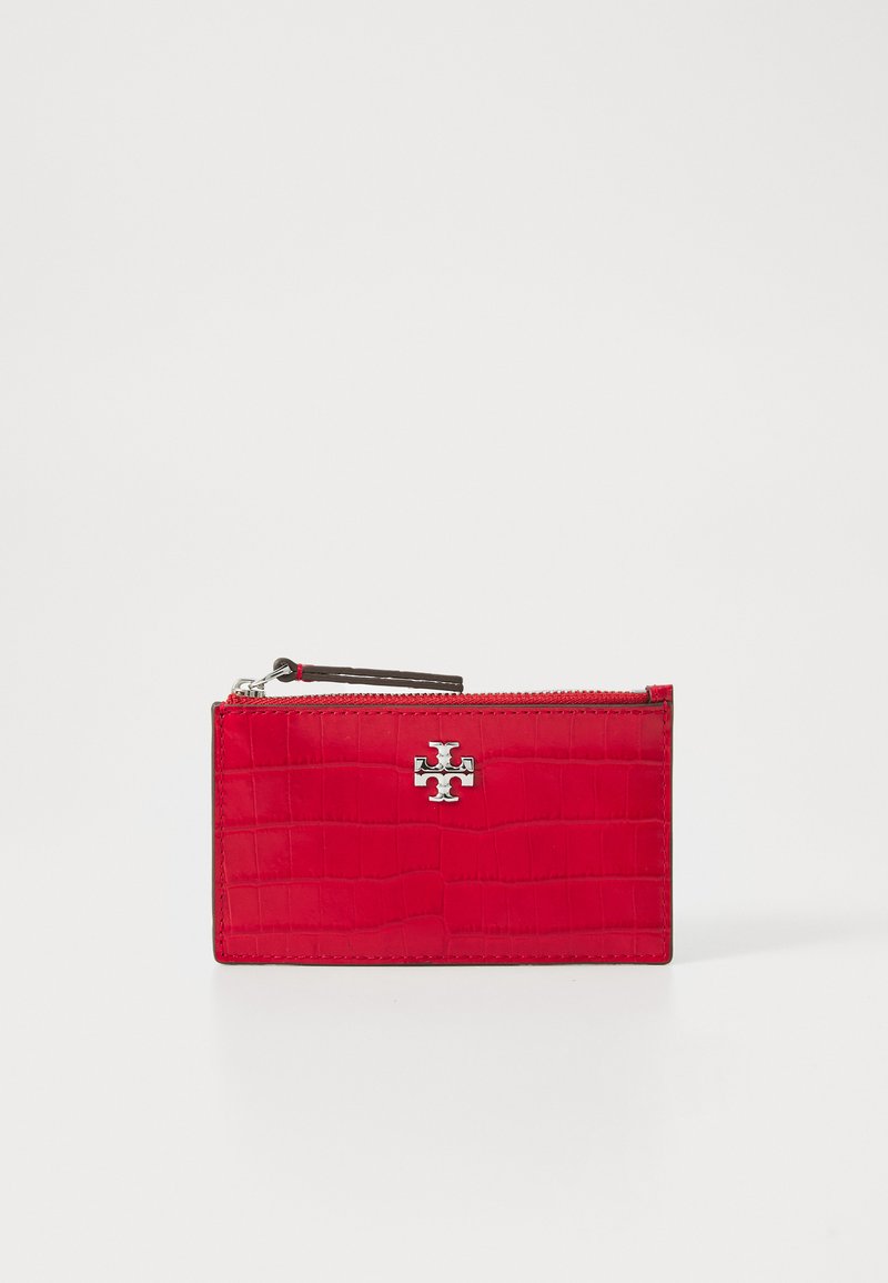 Cartera de cuero rojo con textura de cocodrilo, presenta un logotipo plateado y cierre de cremallera. Forma rectangular compacta, diseño elegante.