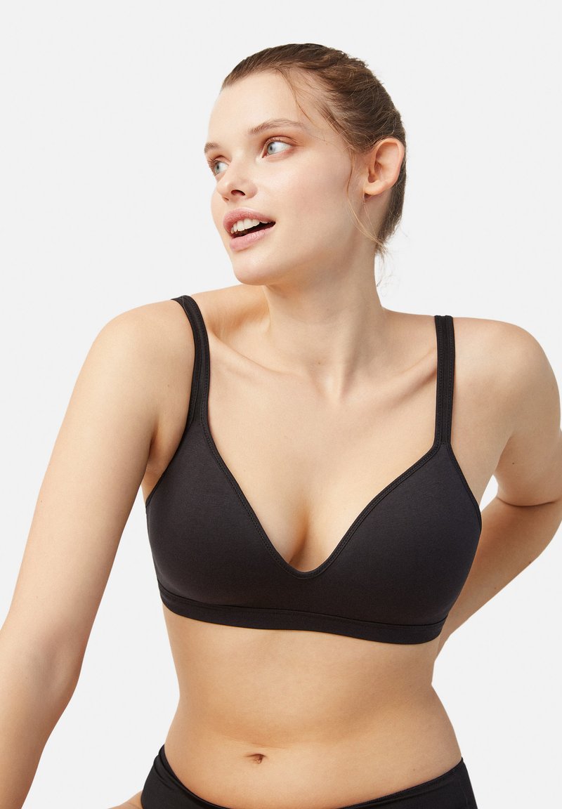 Sujetador inalámbrico negro con diseño de escote en V profundo. Fabricado con tejido suave, con tirantes ajustables y un detalle de costura mínimo.