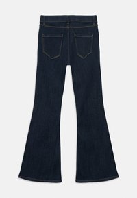 Σκοτεινές μπλε φαρδιές τζιν, κατασκευασμένες από τζιν ύφασμα, με κλασικό σχέδιο πέντε τσεπών και ορατή ραφή. Στο πίσω μέρος υπάρχουν δύο κεκλιμένα τσεπάκια.