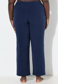 Marineblauwe stretchbroek met een elastische tailleband, een relaxte pasvorm en een zachte textuur, zonder zichtbare patronen of hardware-details.