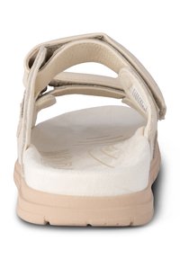 Ljusbeige sandal med en mjuk, texturerad remdesign, öppen baksida, vadderad sula och en lätt gummisula.