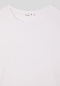 T-shirt bianco con scollatura rotonda, realizzato in tessuto morbido. Presenta un piccolo etichetta del marchio con la scritta "TERRANOVA" e la taglia "S" all'interno del colletto.