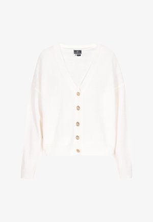 Witte v-hals cardigan van zachte stof. Heeft zes gouden knopen aan de voorkant, geribbelde manchetten en zoom. Overwijdte met verlaagde schouders.