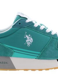 Sneaker suede teal dengan tali putih, aksen tekstur, dan logo terukir pemain polo. Sol karet tebal dengan garis kontras.
