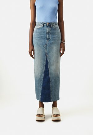 Jeans midi skjørt i lettere vask, med frontsplitt og et mørkere blått panel, høy midje og subtile søm detaljer. Accessorisert med lette sandaler.