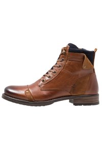 Bottines en cuir marron avec des accents en daim, bout rond, design à lacets et petit talon empilé. Présente un logo sur le côté.