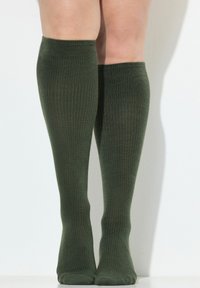 Calze a coste al ginocchio di colore verde scuro. Realizzate in materiale morbido con una texture liscia, presentano un design aderente per il comfort.