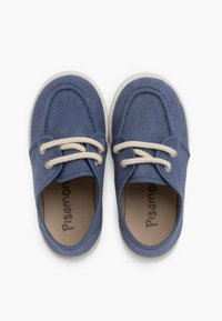 Baskets en toile bleue avec des lacets beiges, semelles en caoutchouc blanc, bout arrondi et détails de couture apparents. Nom de la marque 'Pisamonas' visible à l'intérieur.