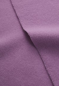 Tessuto in feltro viola con una consistenza morbida, caratterizzato da una leggera peluria e una finitura liscia, che mette in mostra pieghe e dettagli di drappeggio.