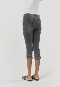 Szare, krótkie dżinsy z denimu o dopasowanym kroju, ozdobnym przeszyciem u dołu oraz dwoma tylnymi kieszeniami z unikalnym wzorem.