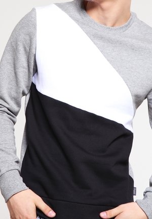 Gray, white, and black crewneck sweatshirt featuring a diagonal panel design with varying materials and textures, long sleeves, and ribbed cuffs.