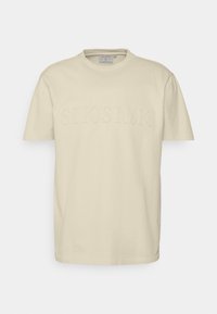 Krátký rukáv, kulatý výstřih, béžové tričko z bavlny. Na přední straně je umístěno vystouplé logo "SIKSILK". Hladká textilie, volný střih.