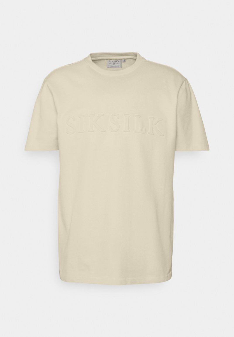 Krátký rukáv, kulatý výstřih, béžové tričko z bavlny. Na přední straně je umístěno vystouplé logo "SIKSILK". Hladká textilie, volný střih.