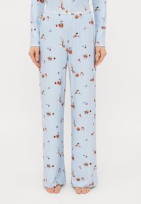 Lyseblå pyjamas sættet med ribbet tekstur, der har et mønster af desserter og drikkevarer. Lange, løst siddende bukser med snor i taljen.