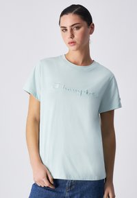 Lichtblauwe katoenen t-shirt met ronde hals en korte mouwen, voorzien van een verhoogd 'Champion' logo op de borst, gladde textuur, casual pasvorm.
