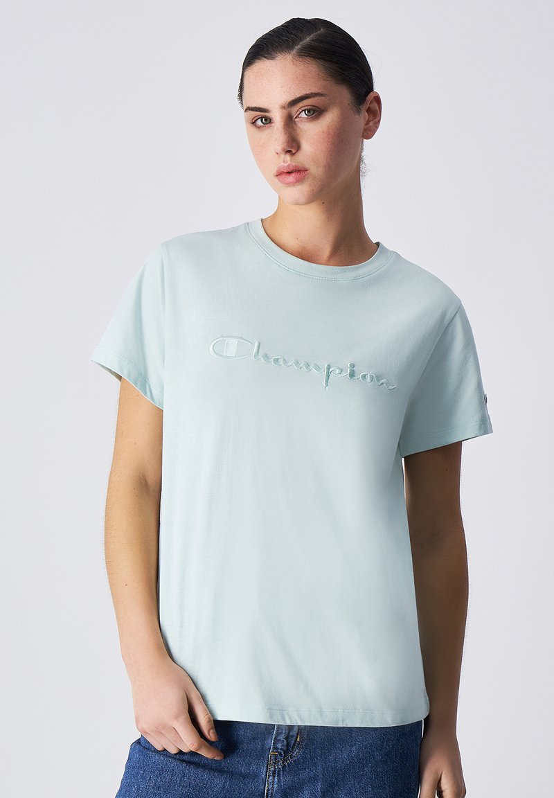 Lichtblauwe katoenen t-shirt met ronde hals en korte mouwen, voorzien van een verhoogd 'Champion' logo op de borst, gladde textuur, casual pasvorm.