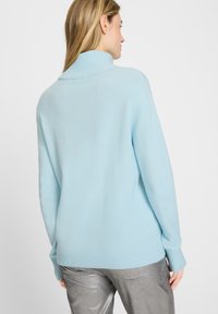 Hellblau, weicher Strickpullover mit hohem geripptem Kragen und langen Ärmeln. Verfügt über eine lässige Passform sowie gerippte Bündchen und Saum.