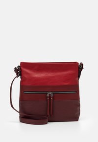 Rød læder crossbody taske med en lynlåslomme foran, justerbar rem og glat tekstur, der har et tofarvet design med mørke accenter.