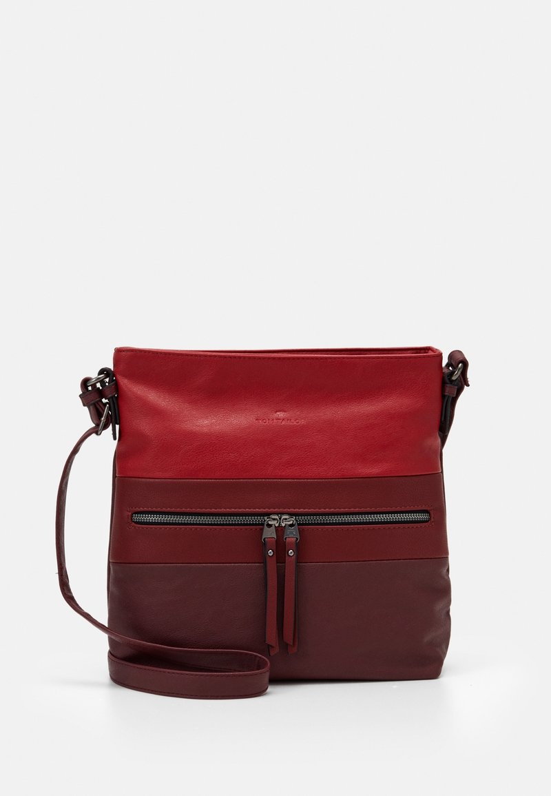 Rød læder crossbody taske med en lynlåslomme foran, justerbar rem og glat tekstur, der har et tofarvet design med mørke accenter.