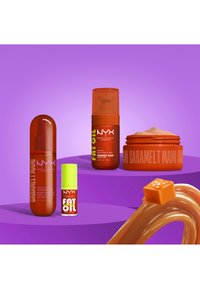 Four NYX Caramelt Mami beauty products in orange and green packaging on purple platforms with caramel swirl and candy piece nearby.