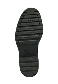 Suela de zapato de goma negra con estrías horizontales, agujeros de drenaje y una superficie texturizada para mayor agarre. El logo de GEOX es visible en el talón.