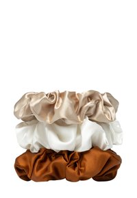 Drie satijn scrunchies gestapeld: bovenin lichtbeige, in het midden wit en onderin diepbruin. Elk heeft een gerimpelde textuur en glanzende afwerking.