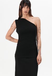 Svart asymmetrisk topp med en skulderdesign, laget av glatt stoff. Har en tettsittende silhuett og lett drapert tekstur.