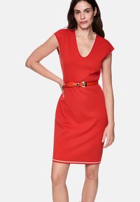 Rotes Kleid mit tiefem V-Ausschnitt und kurzen Kappenärmeln, ausgestattet mit einem kontrastierenden weißen Besatz und einem orangefarbenen Gürtel mit einer metallischen Schnalle, der eine figurbetonte Silhouette schafft.