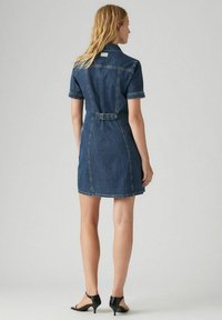 Korte mouw denim jurk in diepblauw, voorzien van een ceintuur in de taille, gestructureerde kraag en contrasterende stiksels. Glad textuur met een aansluitende silhoutte.