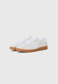 White suede sneakers with a gum rubber sole, featuring white laces, a star logo, and "ALL STAR" printed in gold on the side.
