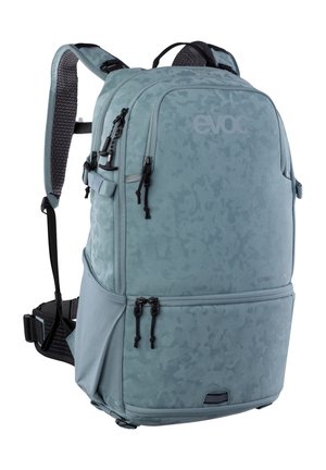 Grande zaino azzurro chiaro con più scomparti con cerniera, spallacci imbottiti, cintura in vita e motivo mimetico discreto.